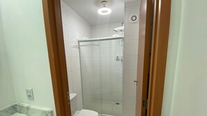 A bathroom with a shower, toilet, and marble sink. - Oceana Suites Cachoeira Paulista (Cachoeira Paulista)