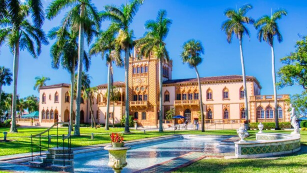 A large building with a courtyard, palm trees, and a fountain. - The Flamingo House - Sarasota (Sarasota)