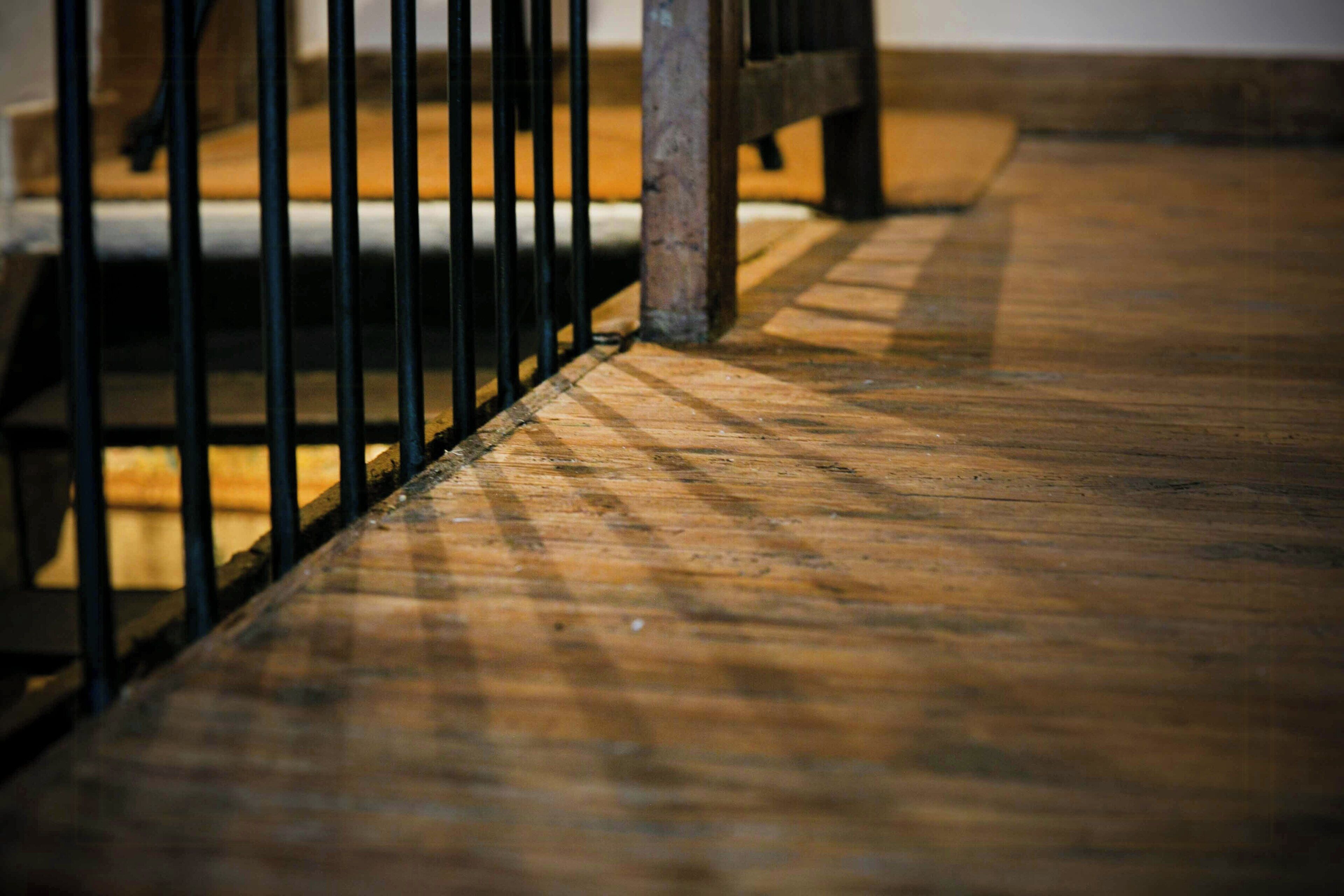 A wooden floor with a metal railing.
