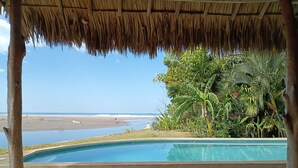 Un espace piscine avec vue sur la plage et les palmiers.