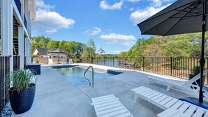 A swimming pool with lounge chairs and a covered area, surrounded by a fence and trees. - Stillwater Overlook (Bedford County)