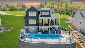 A two-story house with a large front deck, a swimming pool, and a stone retaining wall. - Watermark Bluff (Bedford County)