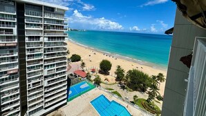 Ein Hochhaus-Hotel mit Pool, Blick auf den Strand und mehreren Balkonen.
