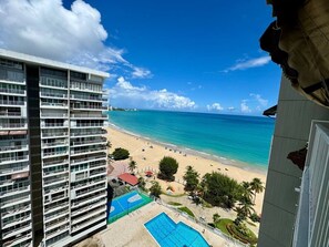 Ein Hochhaus-Hotel mit Pool, Blick auf den Strand und mehreren Balkonen.
