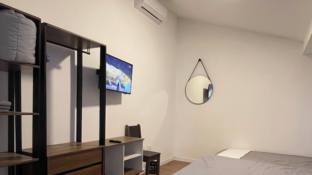 A bedroom with a bunk bed, a desk, a chair, a TV, a mirror, and a bed. - Downtown Florianópolis, everything nearby, comfortable, fully equipped, 4 bedrooms with AC and 2 bathrooms. (Florianópolis)