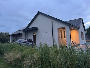 A modern two-story house with a car parked in the driveway.