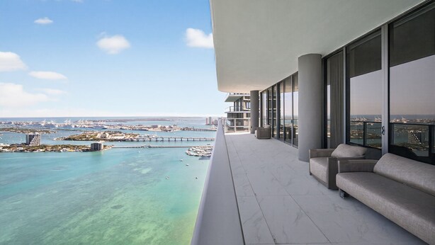 Een balkon met uitzicht op een jachthaven en de skyline.