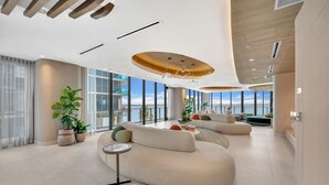 Een modern interieur met een gebogen bank, een kleine ronde tafel en potplanten.