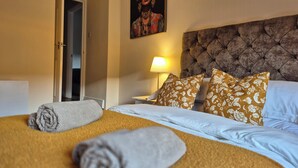 A hotel room with a bed, a nightstand, a lamp, and a door. - City Centre Sanctuary, with free parking. (Worcester)