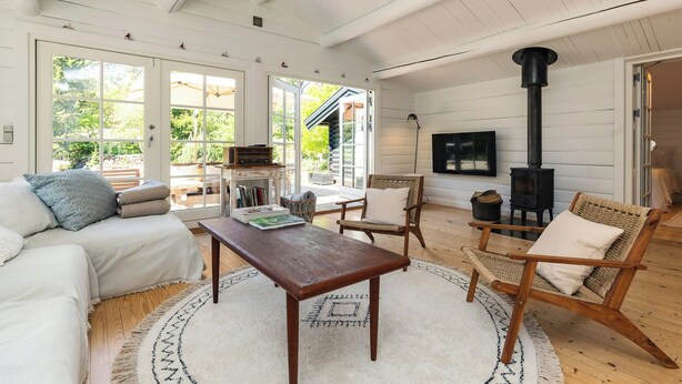 A cozy living room with a sofa, chairs, a table, and a fireplace. - Log cabin with pool near Tisvilde (Vejby)