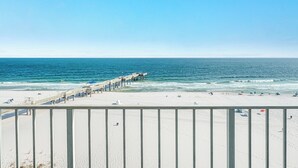 Ein Strand mit einem Pier, der sich ins Meer erstreckt, feinem Sand und einem klaren Himmel.