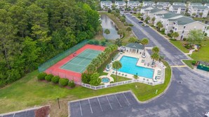 Ein Wohngebiet mit Tennisplatz, Schwimmbad und Mehrfamilienhäusern.