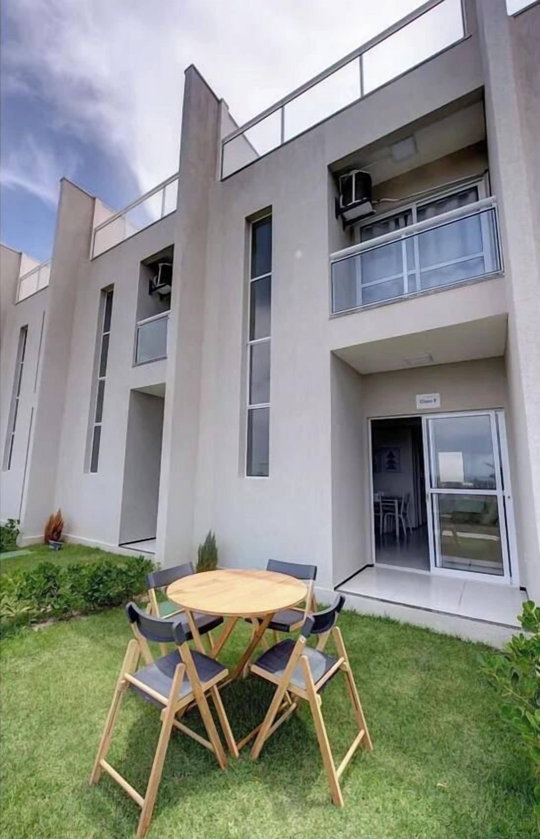 Un edificio moderno con techo plano, ventanas amplias y un balcón.