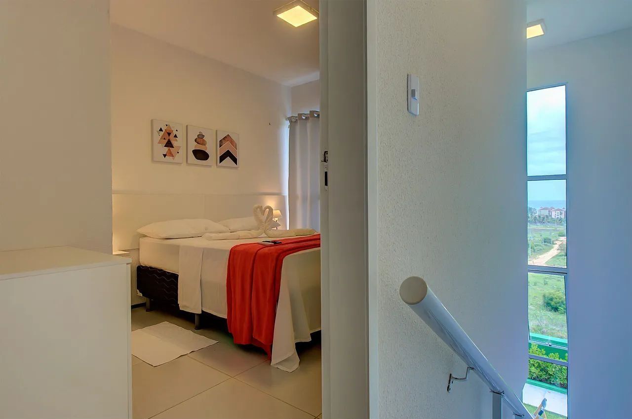 Un dormitorio con cama, mesita de noche y ventana con vistas al exterior.