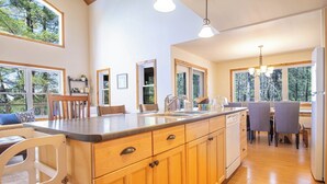 Una cucina moderna con mobili in legno, un'isola grande e un'area pranzo con sedie.