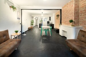 A modern living room with a dining area, a fireplace, and a kitchen in the background. - Spacious 2BR City Center Apartment - Antwerp (Antwerp)