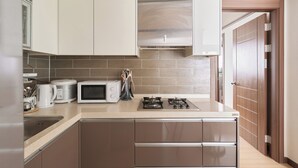 A modern kitchen with stainless steel appliances, a microwave, and a gas stove.