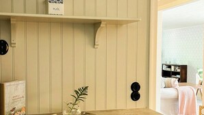 Eine Küche mit Holzausbau, einer Arbeitsplatte und einem Regal mit einem weißen Behälter.