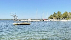 Eine hölzerne Pier, die sich in ruhiges Wasser erstreckt, mit blauem Himmel.