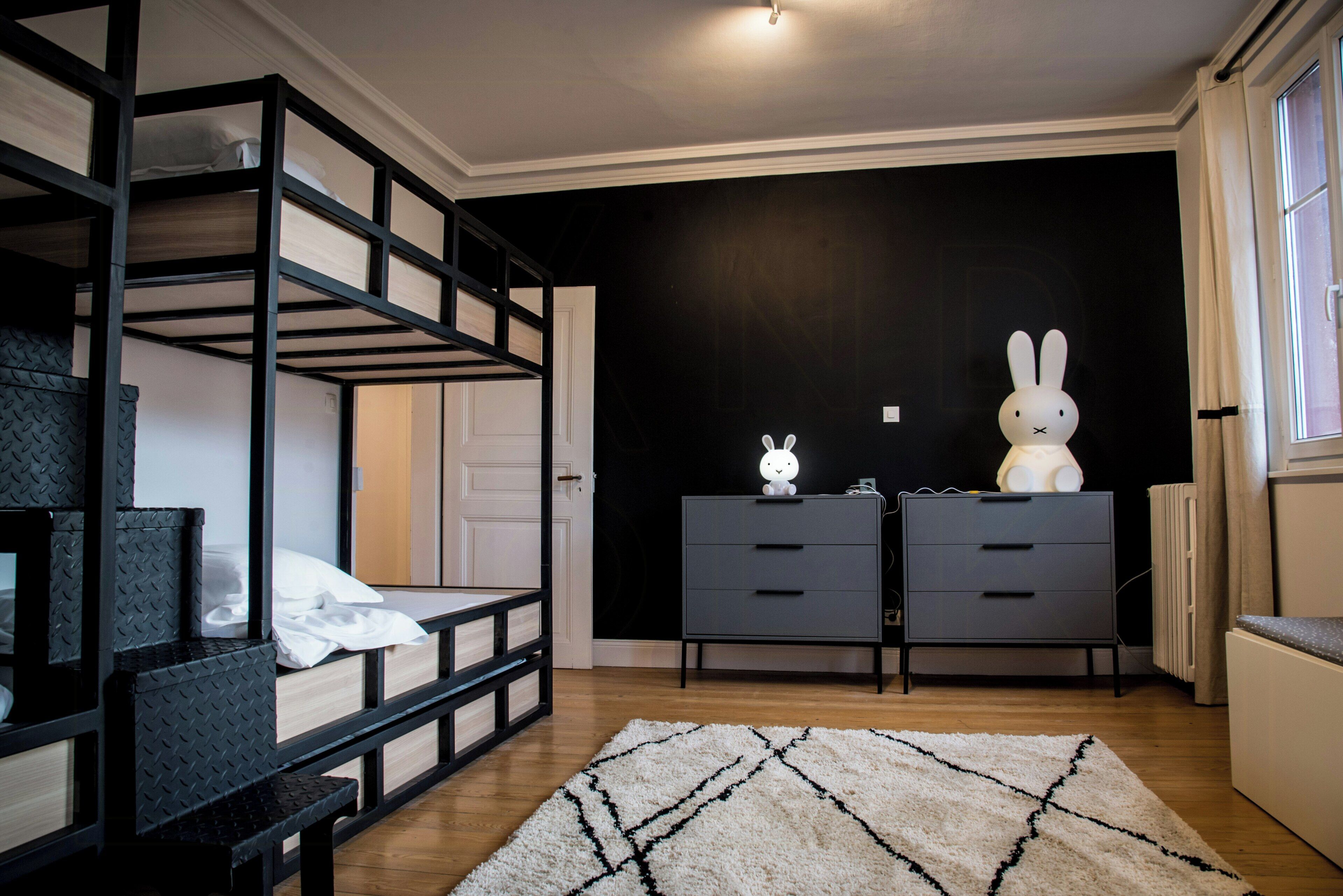 Habitación con literas, un aparador y una gran estatua de conejo blanco.
