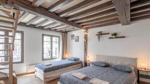 A room with two beds, wooden beams, a ladder, a window, and a plant on a shelf. - Spacious 11-person Stay in Antwerp (Antwerp)