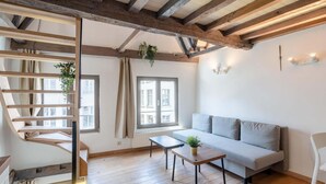A room with a wooden staircase, a sofa, a small table, and a window. - Spacious 11-person Stay in Antwerp (Antwerp)