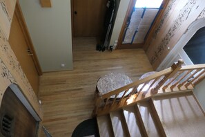 A wooden staircase with a handrail, a stone bench, and a door leading to another room. - World Cup? Beachfront suite, 0.5 hr + ferry ride to Seattle. (Seabeck)