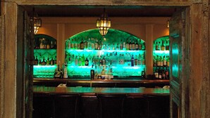 Uma área de bar com um letreiro que diz 'Terry's' acima de um balcão com garrafas e copos.