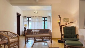 A living room with a sofa, chairs, a coffee table, and a decorative tree sculpture. - Himalaya 6BHK bungalow with AC in Mysuru (Mysuru)