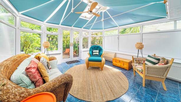 A sunroom with a ceiling fan, wicker furniture, and large windows. - Beautiful Family Home w/ Parking in Central Oxford -Pass the Keys (Oxford)