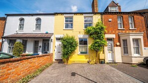 A row of terraced houses with brick walls, a paved driveway, and a clear blue sky. - Beautiful Family Home w/ Parking in Central Oxford -Pass the Keys (Oxford)