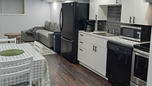 A modern kitchen with a refrigerator, dishwasher, oven, and microwave. - Little cozy home (Belle River)