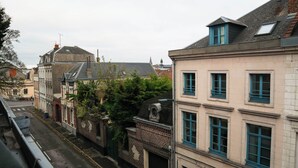 Une vue de rue avec des bâtiments, un ciel dégagé et une rue bien visible.