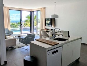 A modern kitchen with a dining area, large windows, and a view of a pool. - Charming Villa with Pool and Spectacular Views (Polop)