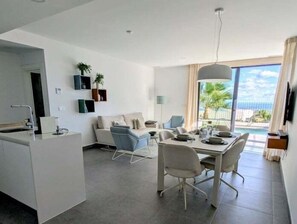 A modern kitchen with a dining area, a sofa, and a view of the ocean. - Charming Villa with Pool and Spectacular Views (Polop)