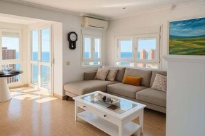 Ein Wohnzimmer mit einer Couch, einem Couchtisch und Meerblick.
