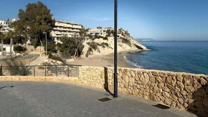 Une promenade en bord de mer, avec des murs en pierre, un lampadaire et des bâtiments en arrière-plan.