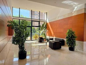 A spacious lobby with a large window, a reception desk, and several potted plants. - Apartment with Sea Views and Covered Parking (Benidorm)