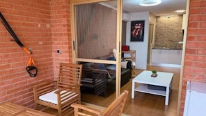 Ein Zimmer mit einer Schiebetür zum Küchenbereich, einem Holztisch und Stühlen sowie einem Deckenventilator.