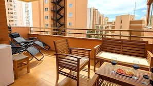 Ein Balkon mit Tisch, Stühlen und einem Kühlschrank.