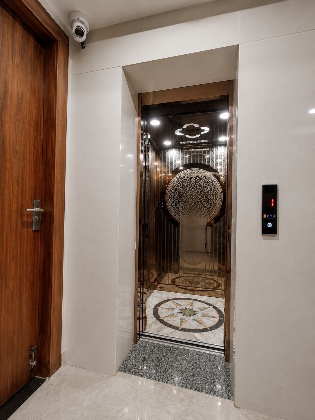 A modern elevator interior with a patterned wall, a security camera, and a digital display.