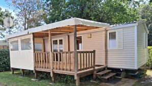 Ein Wohnmobil mit Veranda, einer überdachten Terrasse und einem kleinen Anbau.