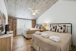 A room with two beds, a ceiling fan, a TV, and a window with curtains. - 378 Wahoo Drive - Canal Front Home (Fripp Island)