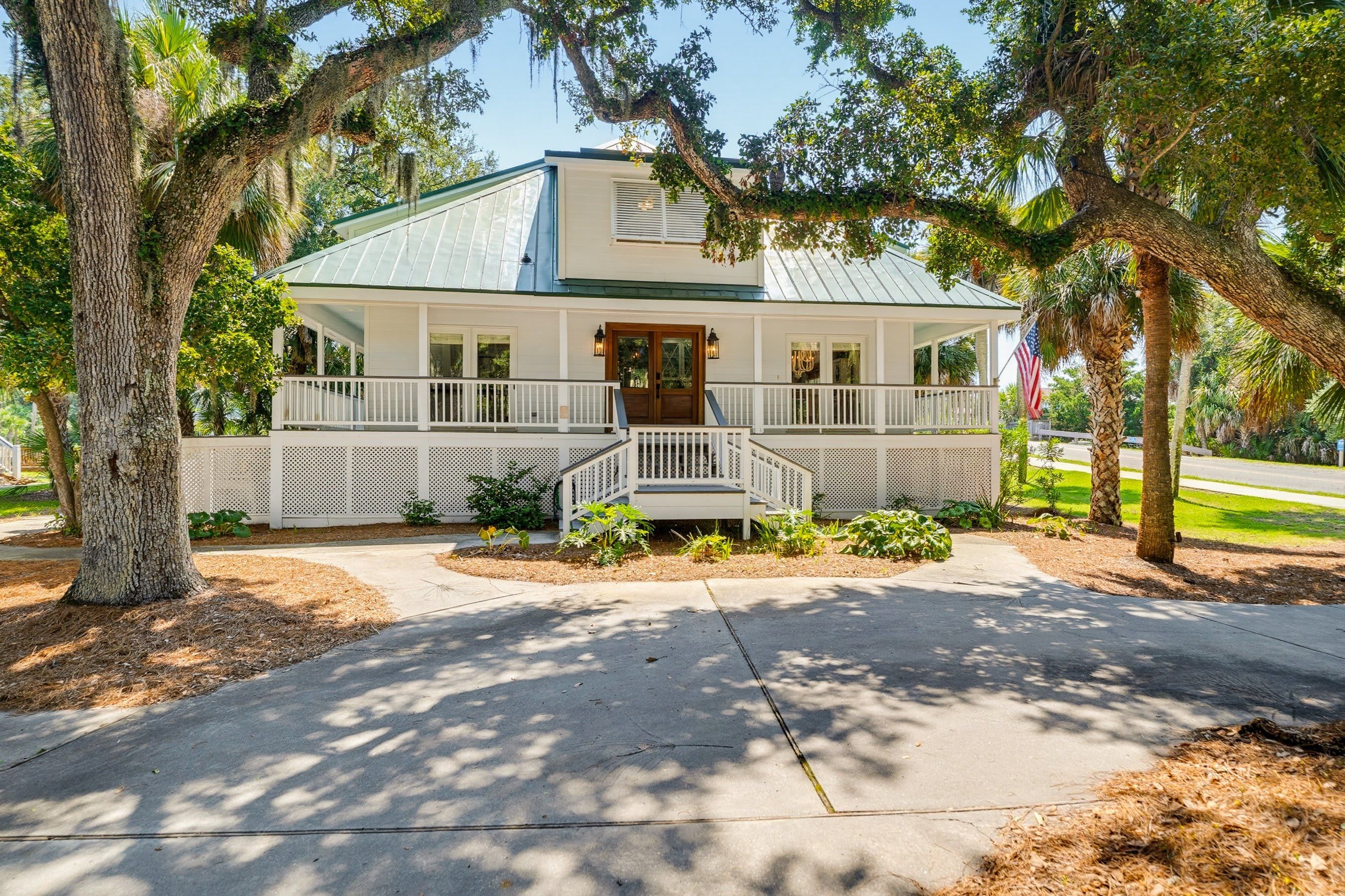 A two-story house with a porch, a front door, and a flag.