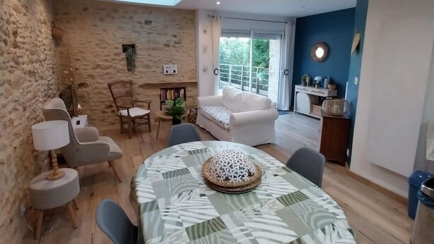 Zona pranzo con tavolo rotondo, sedie, una lampada e un oggetto decorativo sul tavolo.