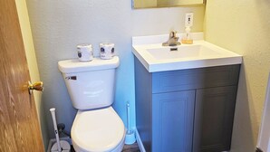 A bathroom with a toilet, sink, mirror, and wooden flooring. - 6 Bedroom - 5.5 Bath - Second Tier (Climax Springs)
