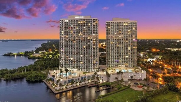 A high-rise hotel with multiple floors, a pool, and a waterfront view. - Waterfront apartment (Fort Myers)