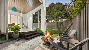 A patio with a fire pit, outdoor furniture, and a view of the backyard. - The Boat House- Casuarina Beachfront Home (Casuarina)