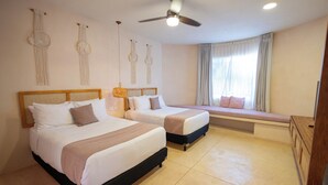 A hotel room with two beds, a ceiling fan, a window with curtains, and wall decor. - Los Pavitos, double room at Casa Sofía (Mérida)