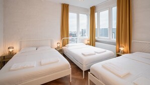 A hotel room with two beds, a city view, and a hanging light fixture. - Grand Central Station 2br/14p Apartment (Antwerp)